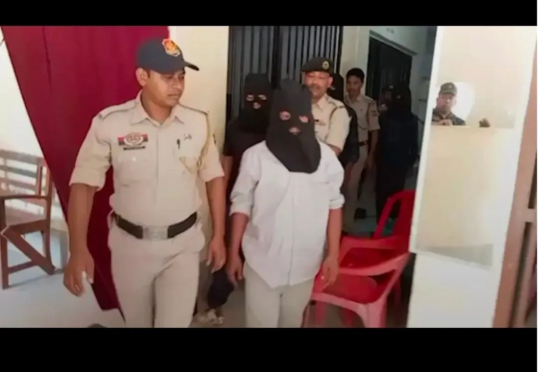 Police escort the detained accused.